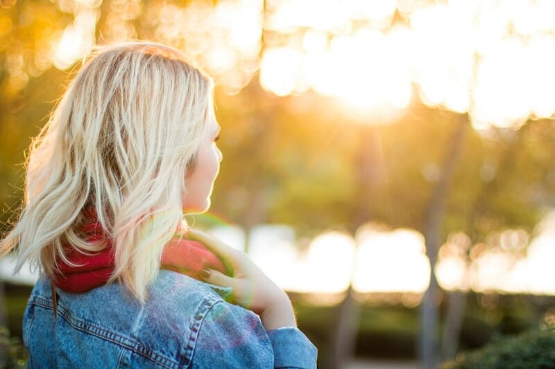blonde feminine looking person looking into sunset