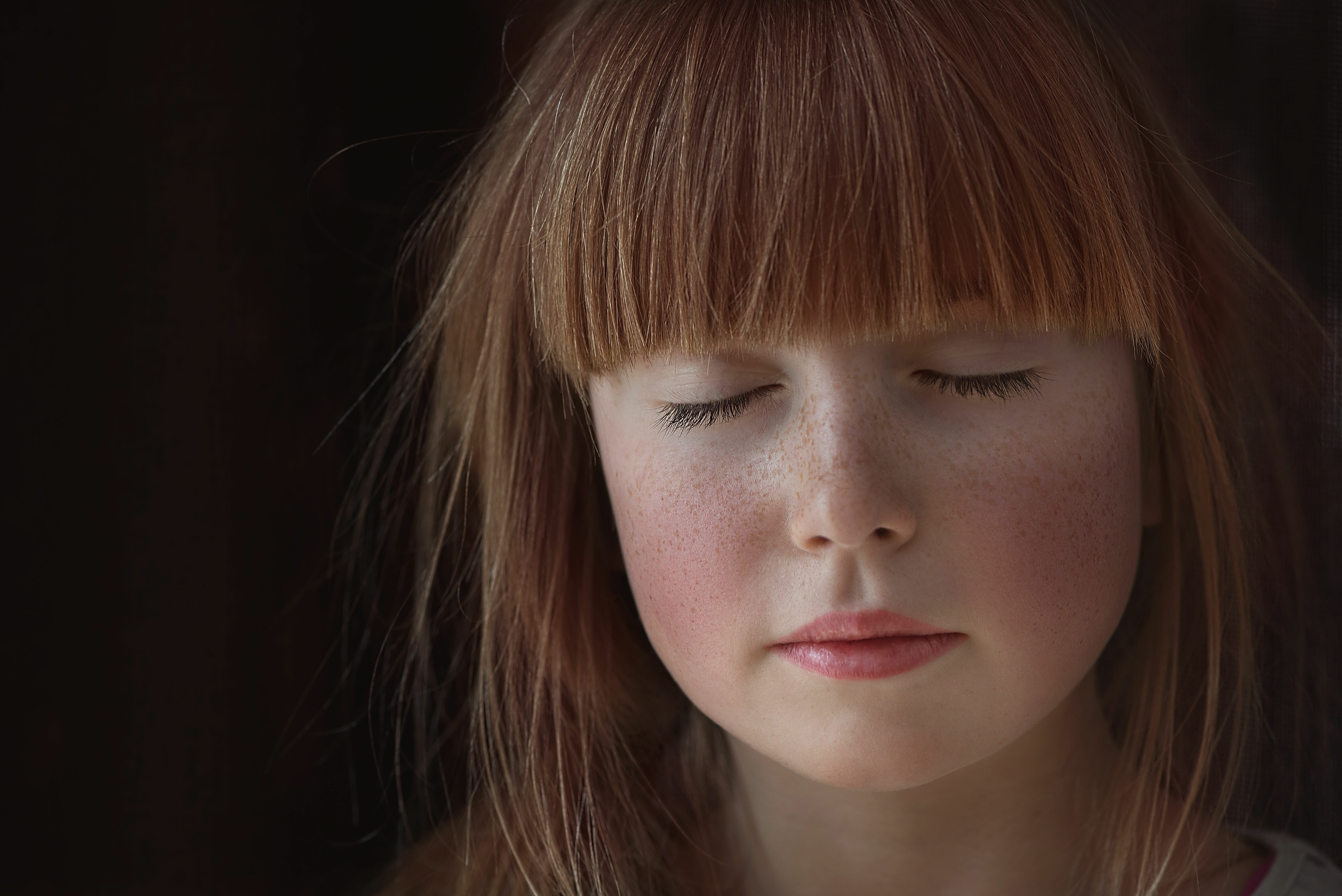 child with red hair and bangs