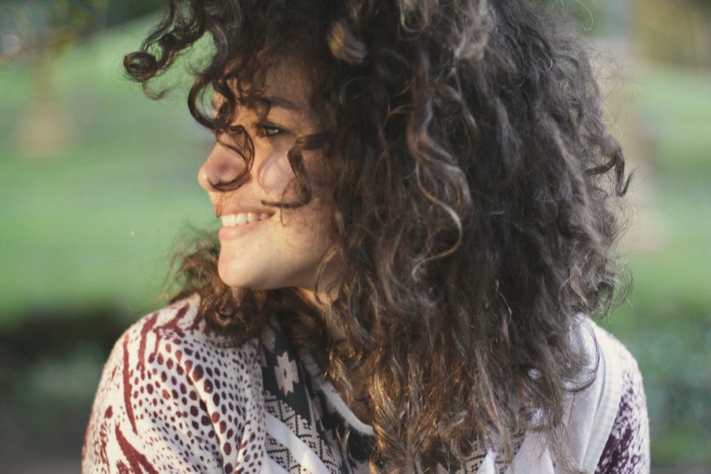 Woman with curly hair looking at her right